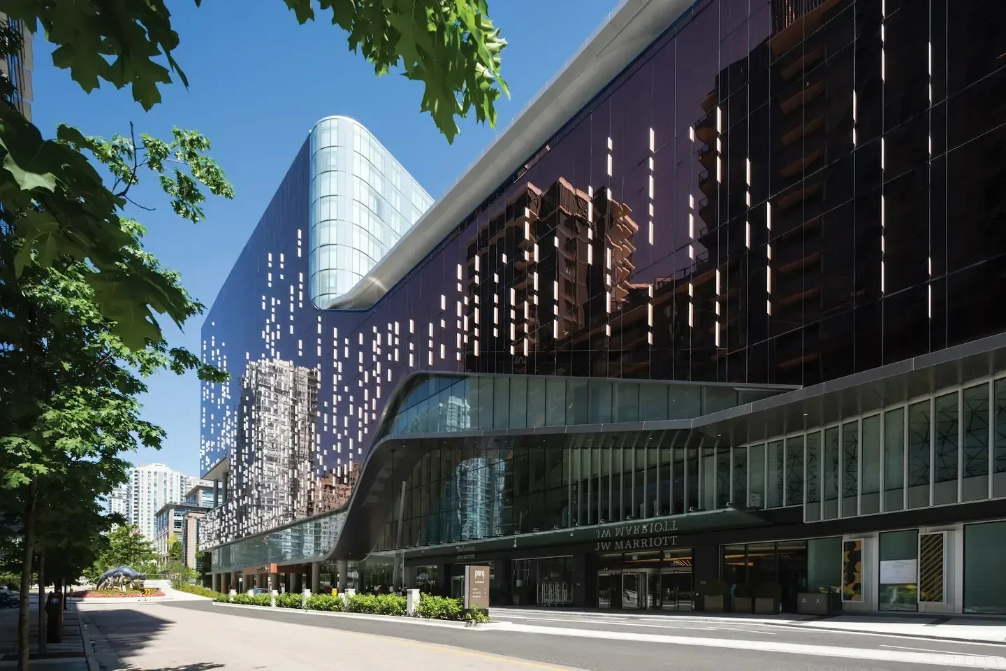 The glass facade of the JW Marriott Parq Vancouver on a sunny day in downtown Vancouver, British Columbia