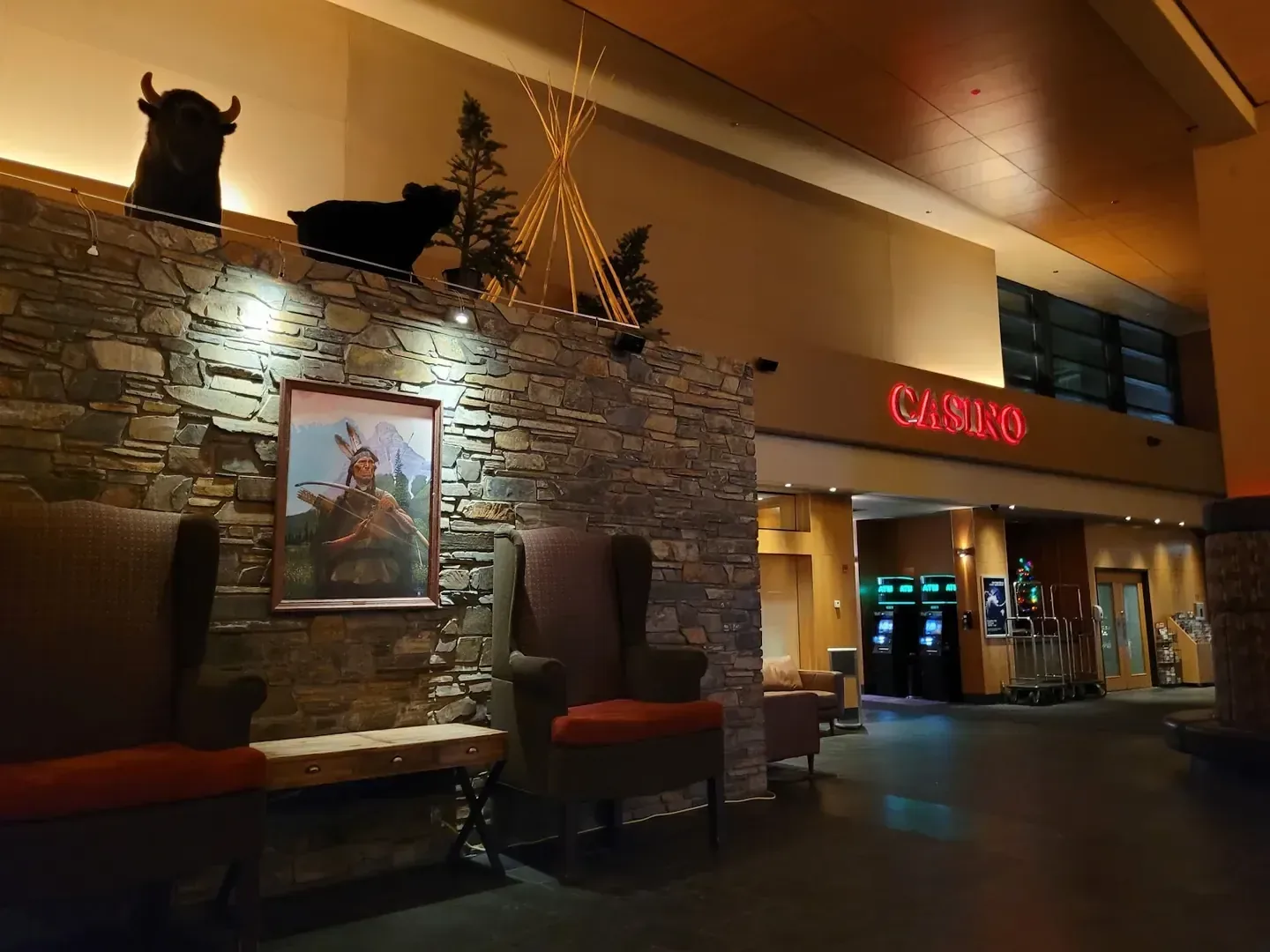 Stoney Nakoda Resort & Casino lobby in Kananaskis, with stone wall, armchairs and mountain artwork